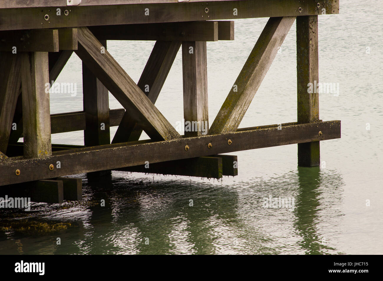 The intricate support beam structure of the viewing platform pier overlooking the  busy  Southampton Water at Hythe in Hampshire on the south coast of Stock Photo