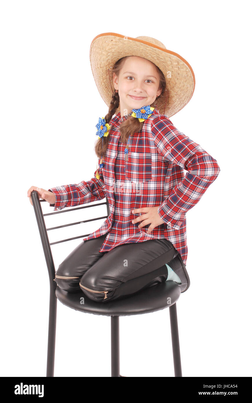 Portrait of adorable smiling little girl sitting on a chair with her hat,  isolated on a white background with soft shadow Stock Photo