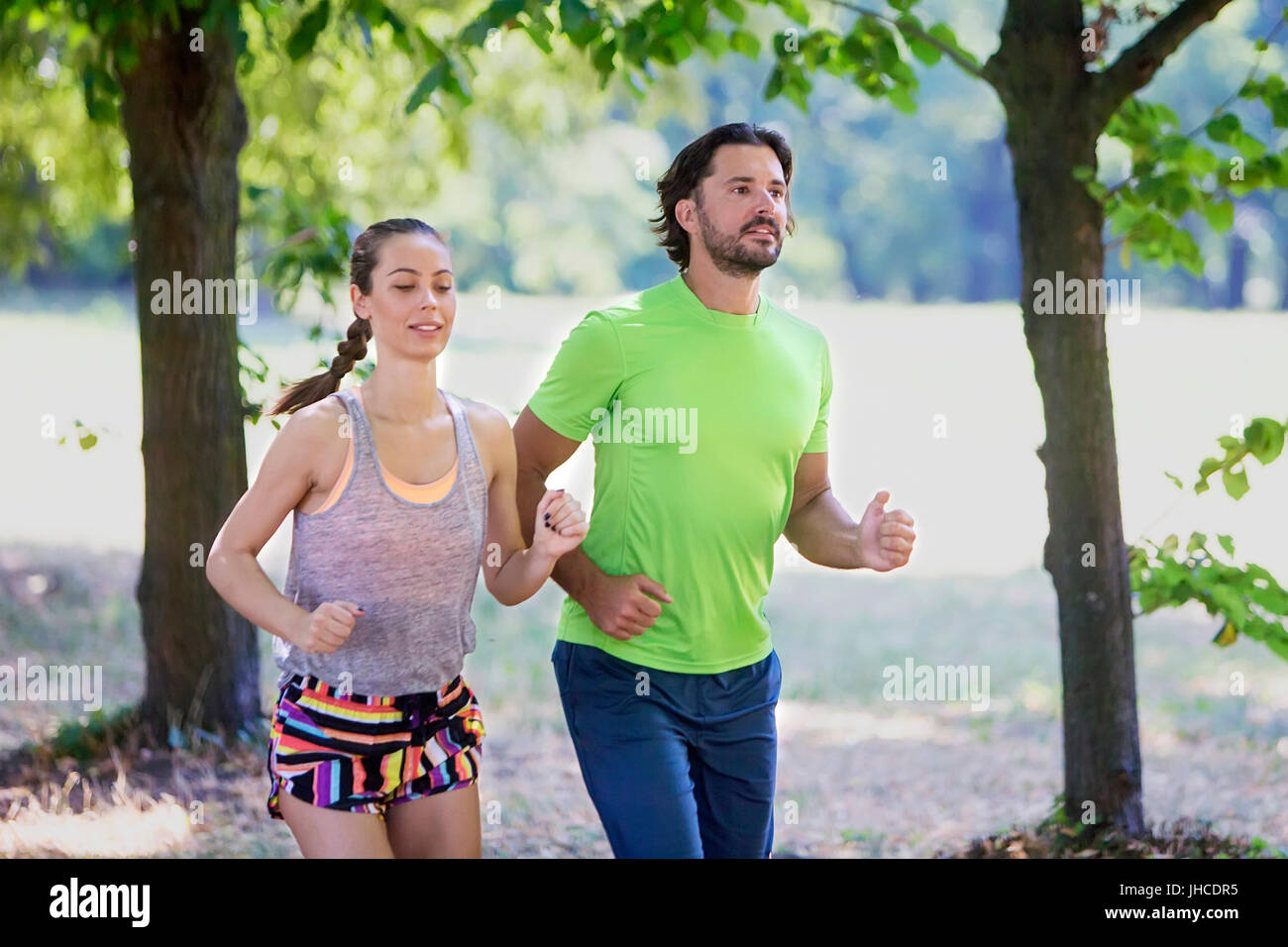 Young couple running in nature on a sunny summer day Stock Photo