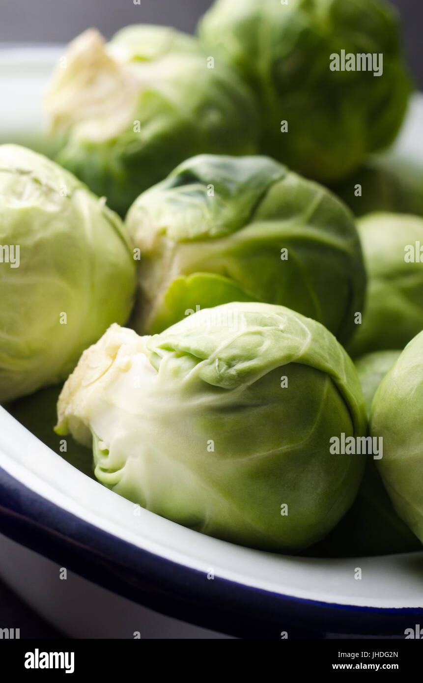 Close up of brussel sprouts piled into a white enamel baking tin. Stock Photo