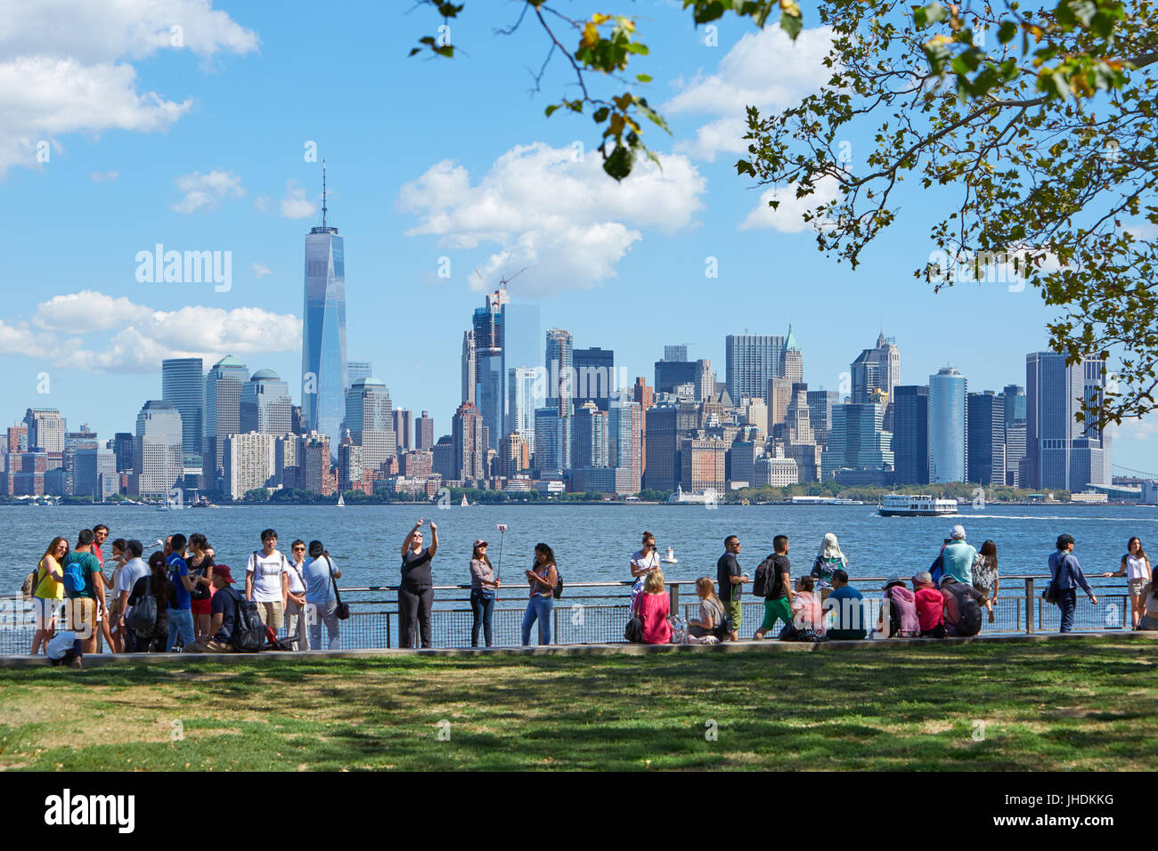 People and tourists shooting selfies and looking at New York city skyline in a sunny day in New York Stock Photo