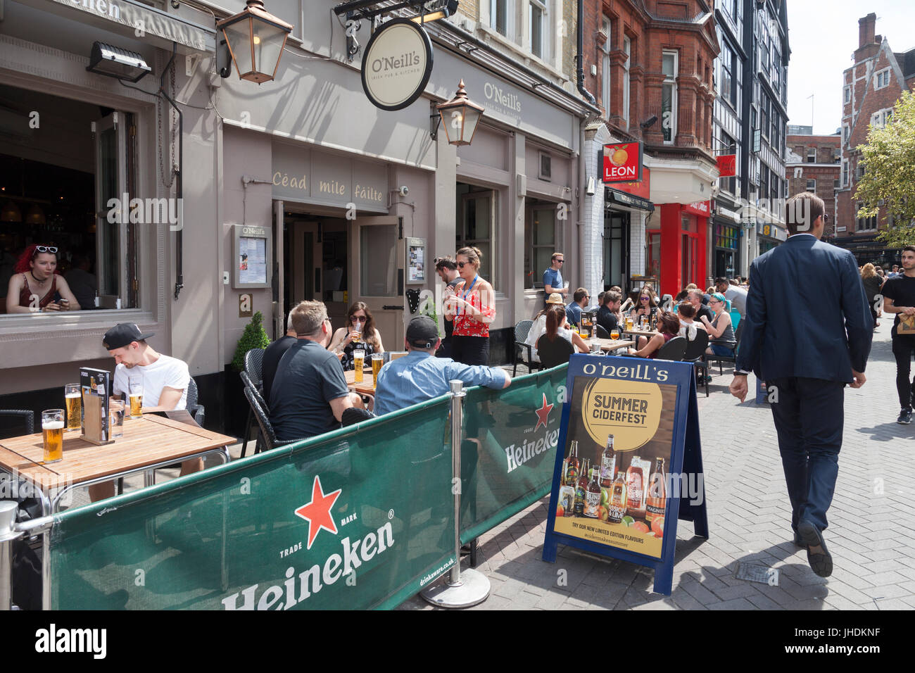 The north end of Carnaby Street, London. O'Neill's Irish Pub with customers drinking outside, Leon naturally fast food, Ben's Cookies, EE telecommunic Stock Photo