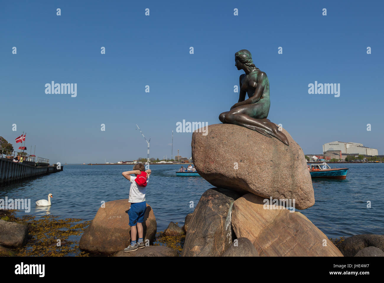 A boy at The Little Mermaid statue in Copenhagen, Denmark. Stock Photo