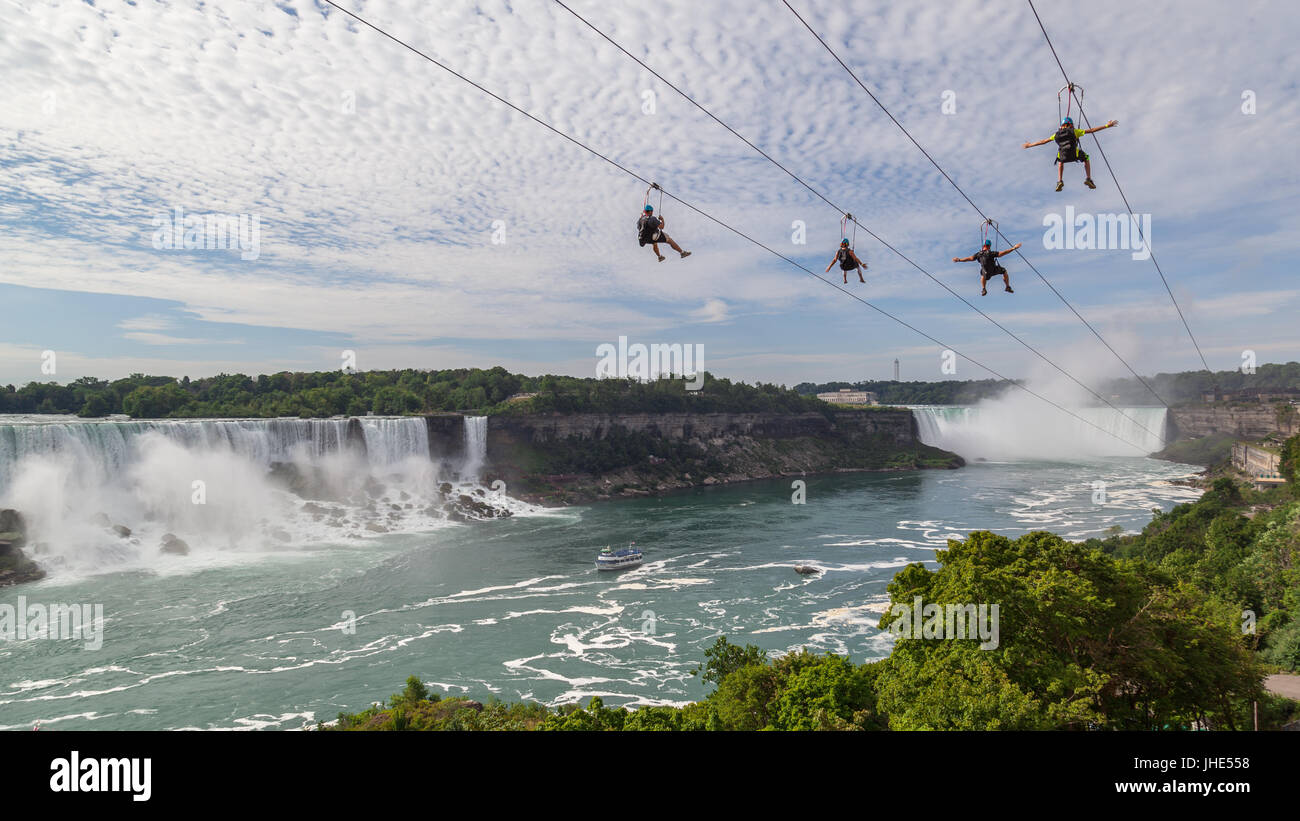 Four unrecognizable people taking zipline ride at Niagara Falls on Sep. 4, 2016, Ontario. Stock Photo