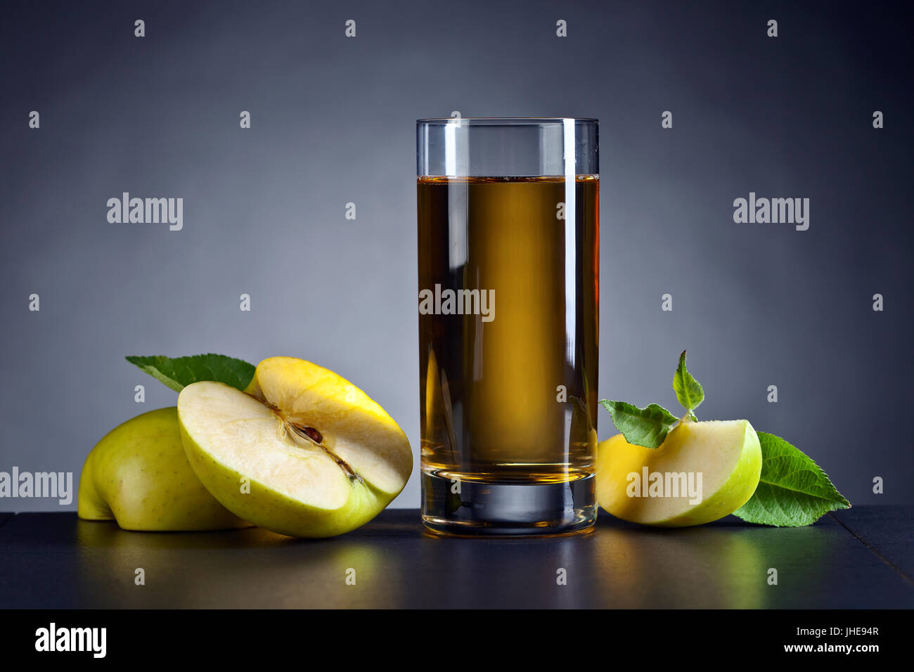 Green apples and a glass of apple juice on a black ceramic table Stock ...