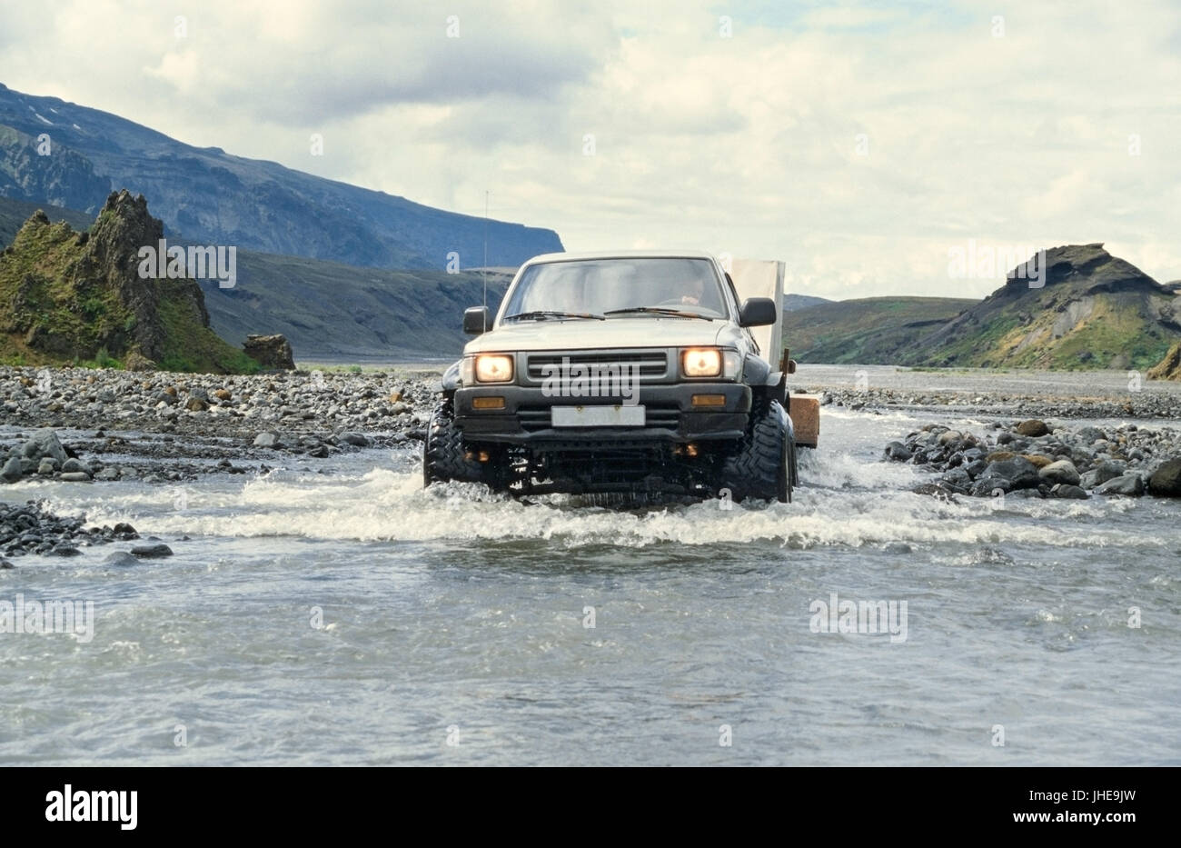 Car pulling trailer and crossing river in Iceland Stock Photo