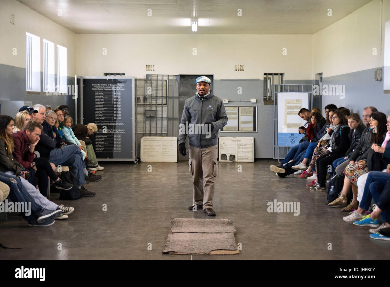 Tourists and prisioner in prisoners cell on Robben Island, Robben Island, prison grounds for political prisoners during apartheid in South Africa. Stock Photo