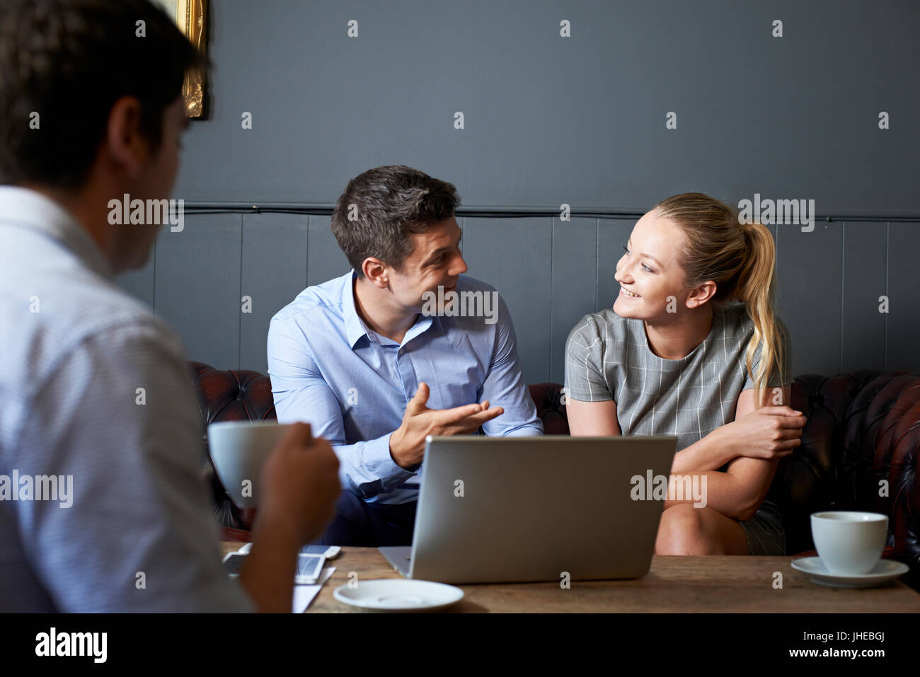 Three Businesspeople Having Meeting In Cafe Stock Photo