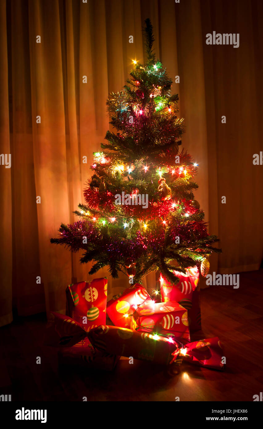 decorated Christmas tree with wrapped presents under Stock Photo