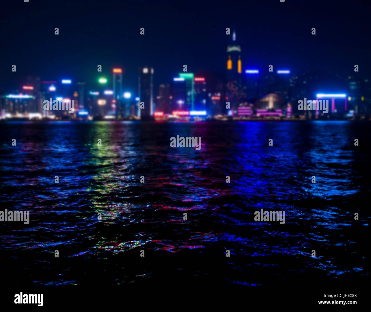 view of skyscrappers  shining with colourful lights in Hong Kong bay at night Stock Photo