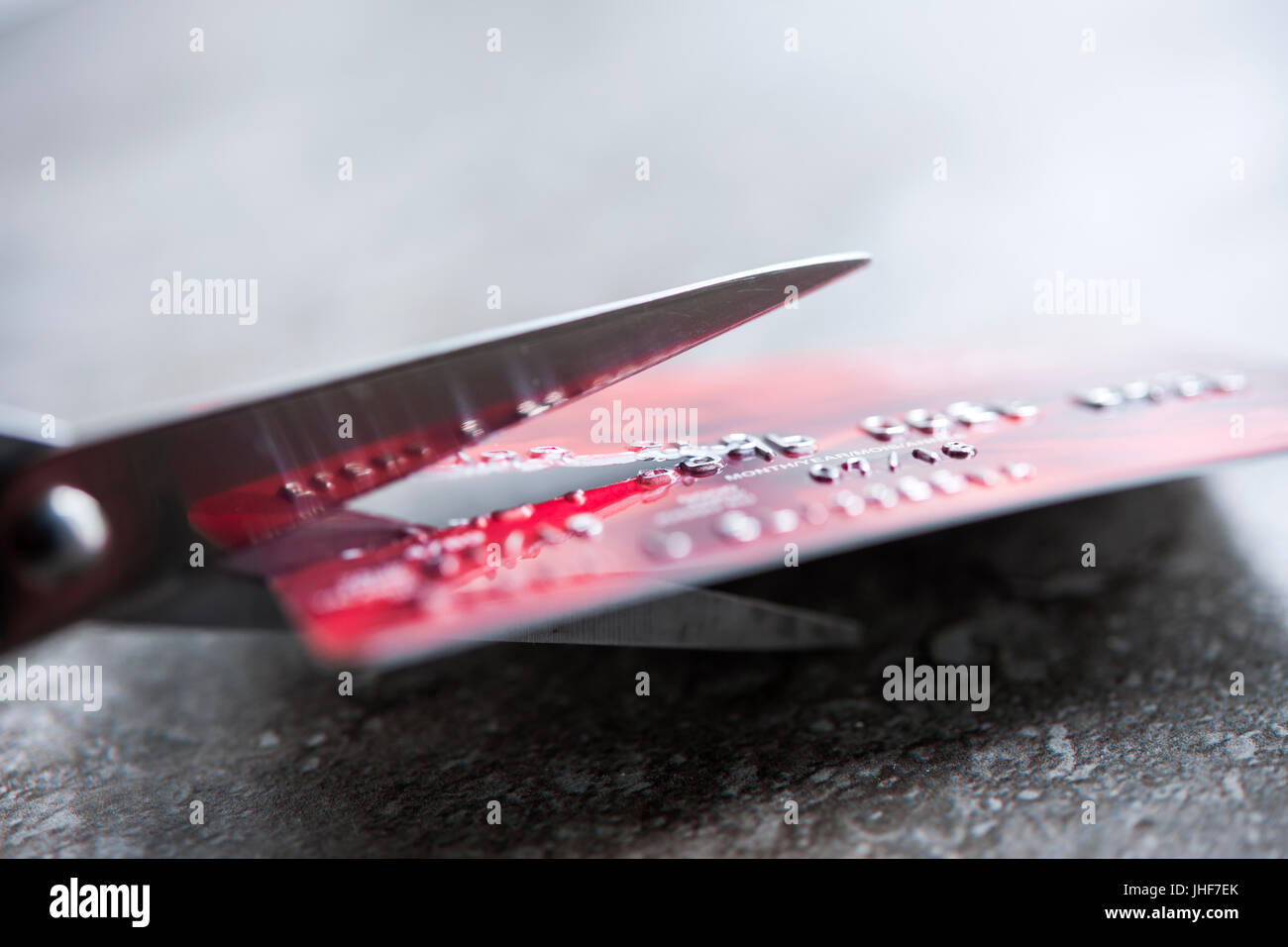 Credit card being cut with scissors, close up with copy space Stock Photo