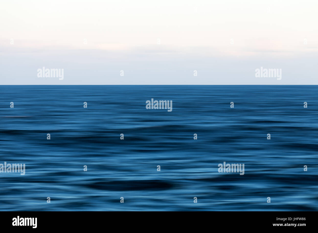 An abstract long exposure pan of the blue ocean and horizon. Stock Photo