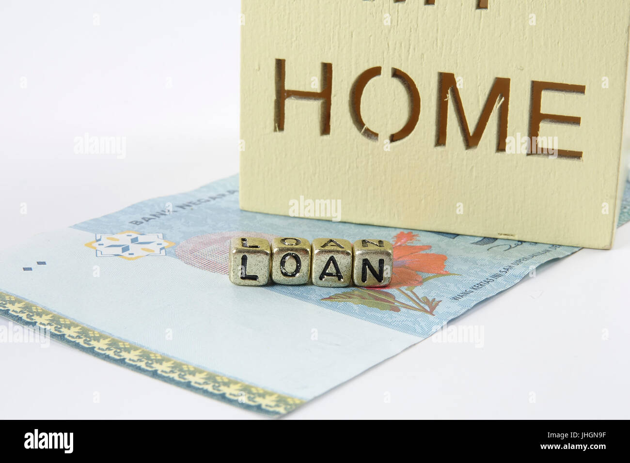 Housing loan concept. Small house and coin isolated on white background. Copy space Stock Photo