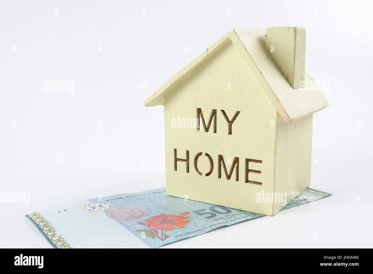 Housing loan concept. Small house and coin isolated on white background. Copy space Stock Photo