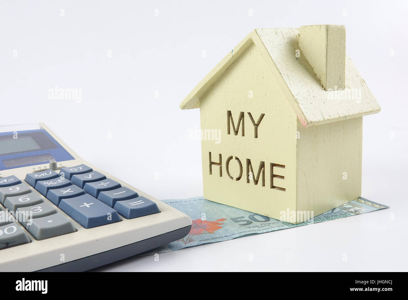 Housing loan concept. Small house and coin isolated on white background. Copy space Stock Photo