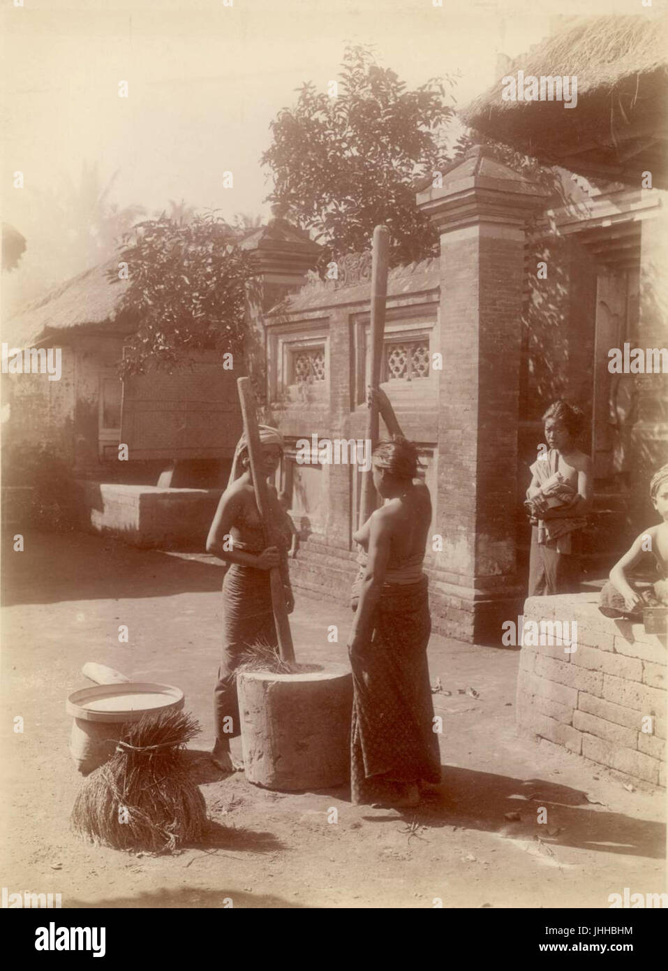 KITLV - 90543 - Kurkdjian - Sourabaia-Java - Women pounding rice in Bali - circa 1910 Stock Photo