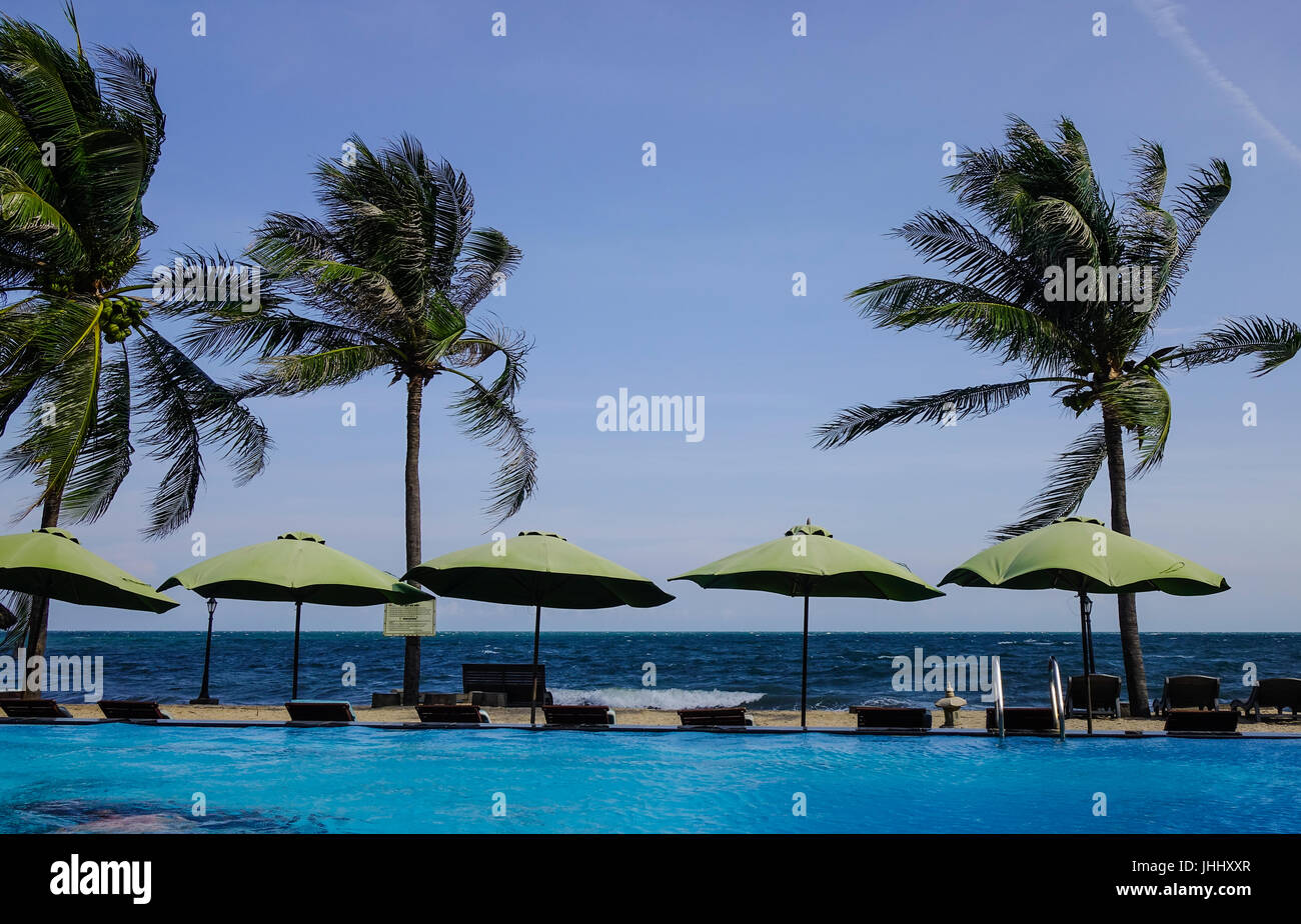 Phan Thiet, Vietnam - Mar 26, 2017. Swimming pool with palm trees in Phan Thiet, Vietnam. Phan Thiet belongs to Binh Thuan province and located 200km  Stock Photo