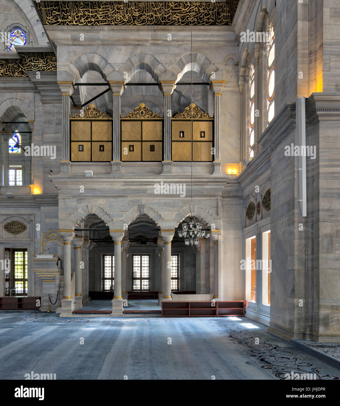 Interior of Nuruosmaniye Mosque, an Ottoman Baroque style mosque built in 1755, with arcades, wooden doors, windows, and blue carpet, located in Shemb Stock Photo