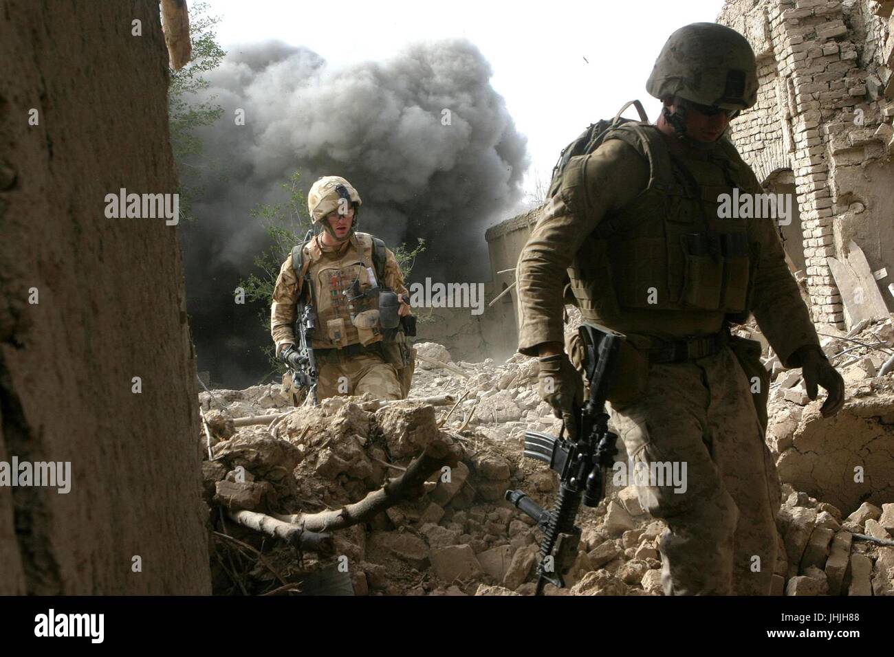 U.S. and Estonian soldiers walk over rubble as a controlled detonation explodes behind them October 26, 2008 in Now Zad, Afghanistan.    (photo by Freddy G. Cantu via Planetpix) Stock Photo