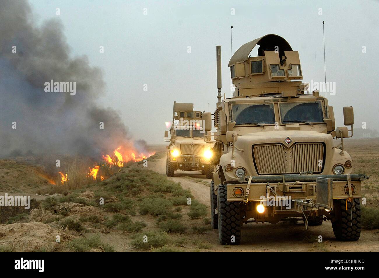 U.S. soldiers conduct a mounted patrol in mine-resistant ambush-protected vehicles after setting canal vegetation ablaze during the Iraq war July 30, 2008 in Tahwilla, Iraq.    (photo by David J. Marshall  via Planetpix) Stock Photo