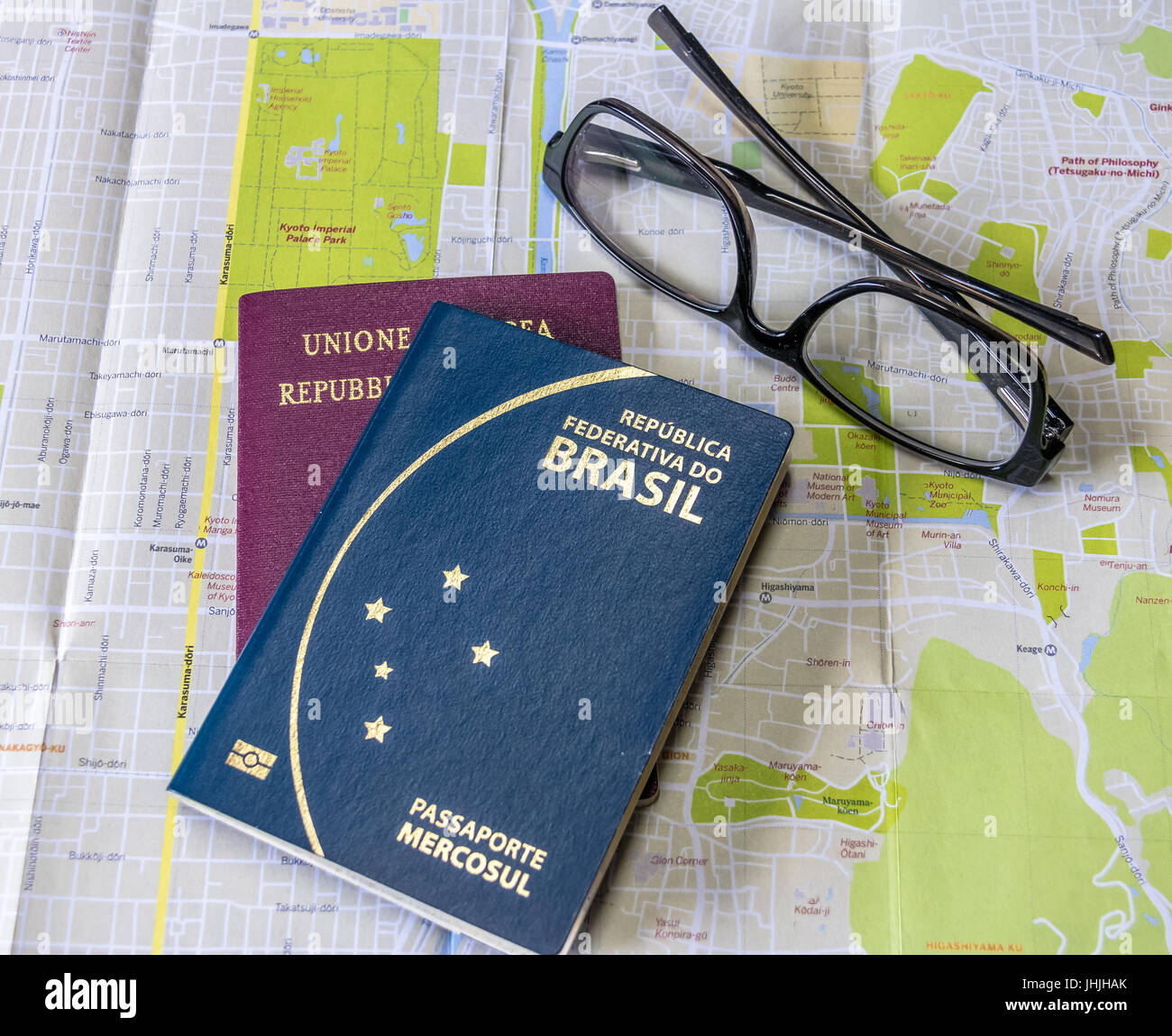 Planning a trip - Brazilian and Italian passports on city map with glasses Stock Photo