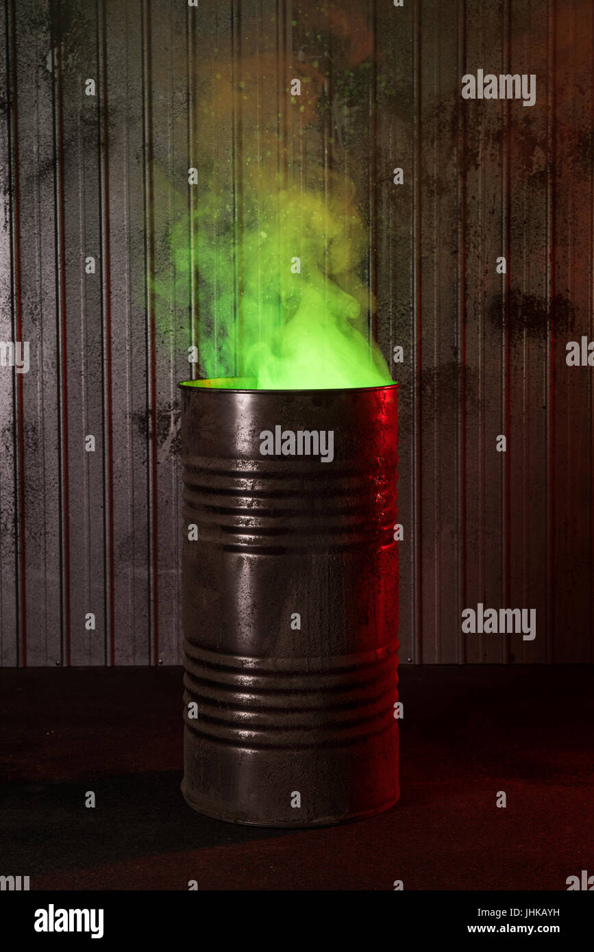Post-apocalyptic background with old rusty barrel and green toxic smoke Stock Photo
