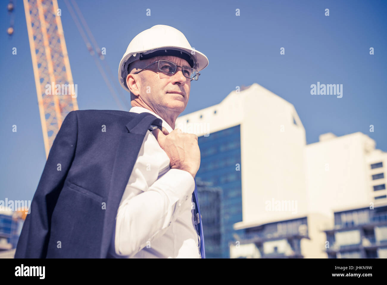Senior elegant builder man in suit at construction site on sunny Stock ...