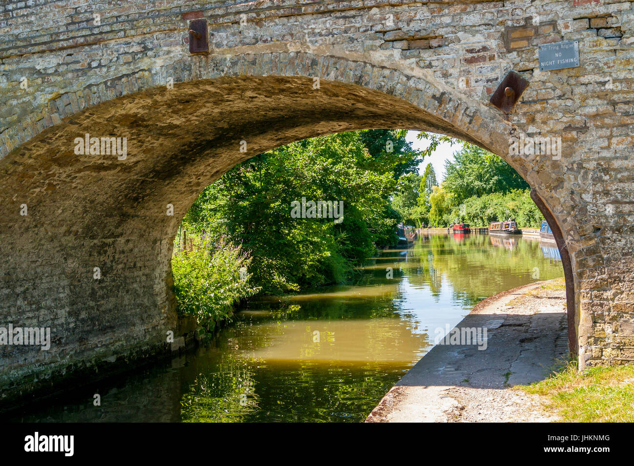 Bridge over the Grand Union Canal at Marsworth in the Vale of Aylesbury, Bucks, UK, with narrow boats in the background Stock Photo