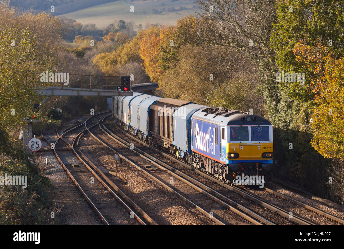 A class 92 electric locomotive number 92017 in Stobart Rail livery working a freight train at Otford Junction in Kent. Stock Photo