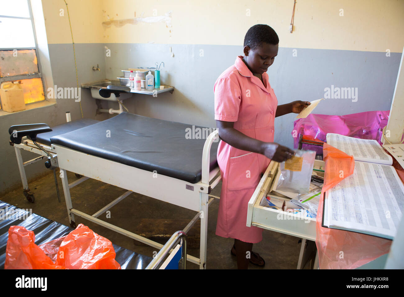 A midwife, looking for some medical equipment in the delivery room at Bukeeri Health centre 3, in Masaka district, Bungasa county, Uganda. Stock Photo