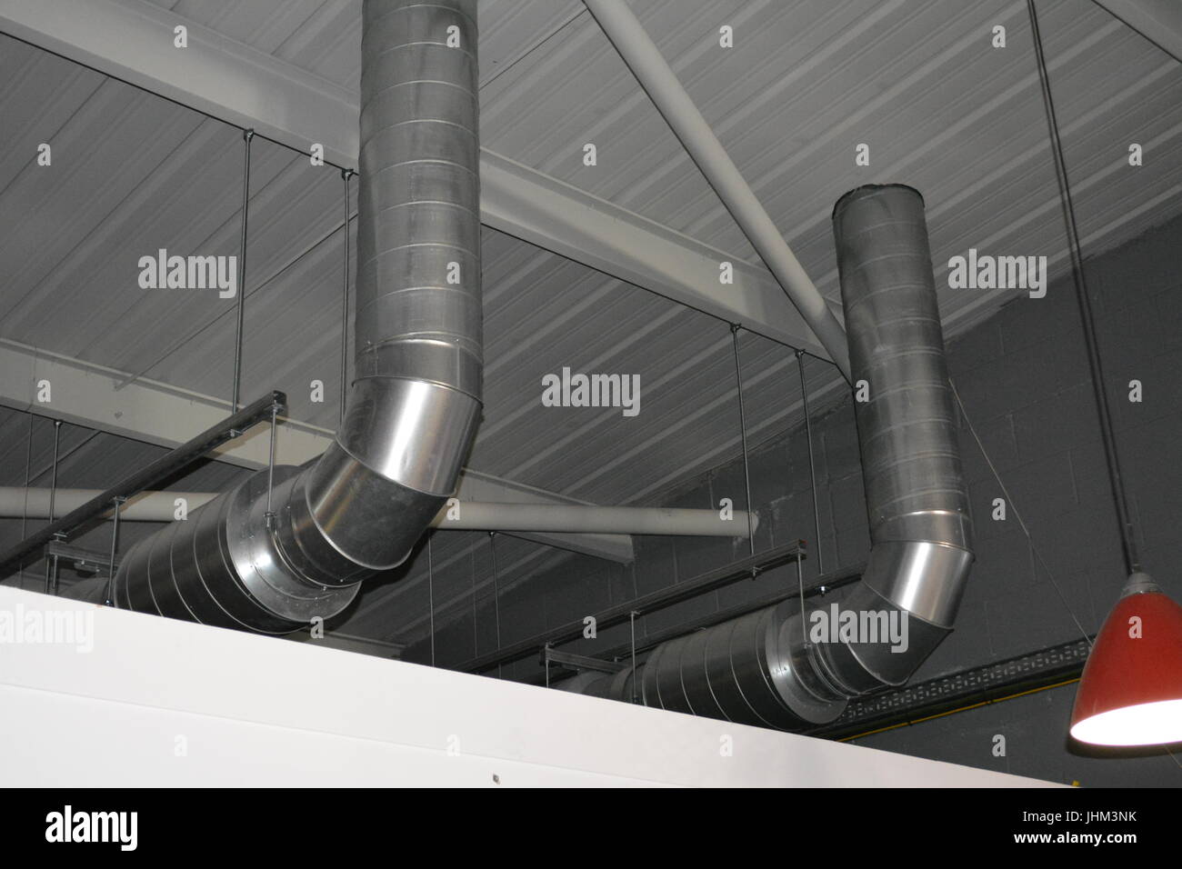 Large profile duct ducting ventilation pipe extraction in shed warehouse building re heating air exchange piping industrial insulated roof space Stock Photo