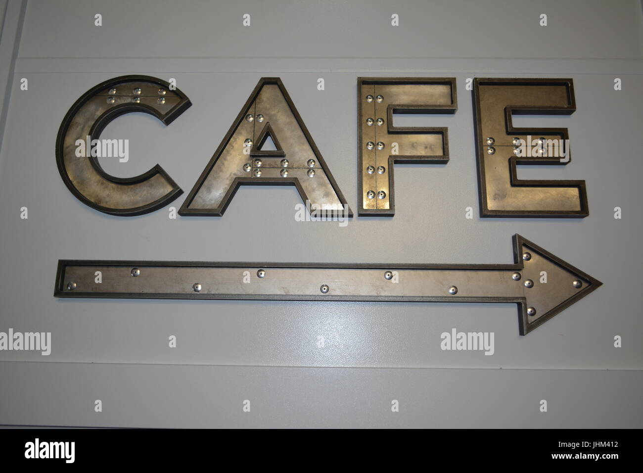 Large metal letters direction sign and arrow pointing to cafe re indoor cafe sign re eating and drinking re socialising meeting friends Stock Photo