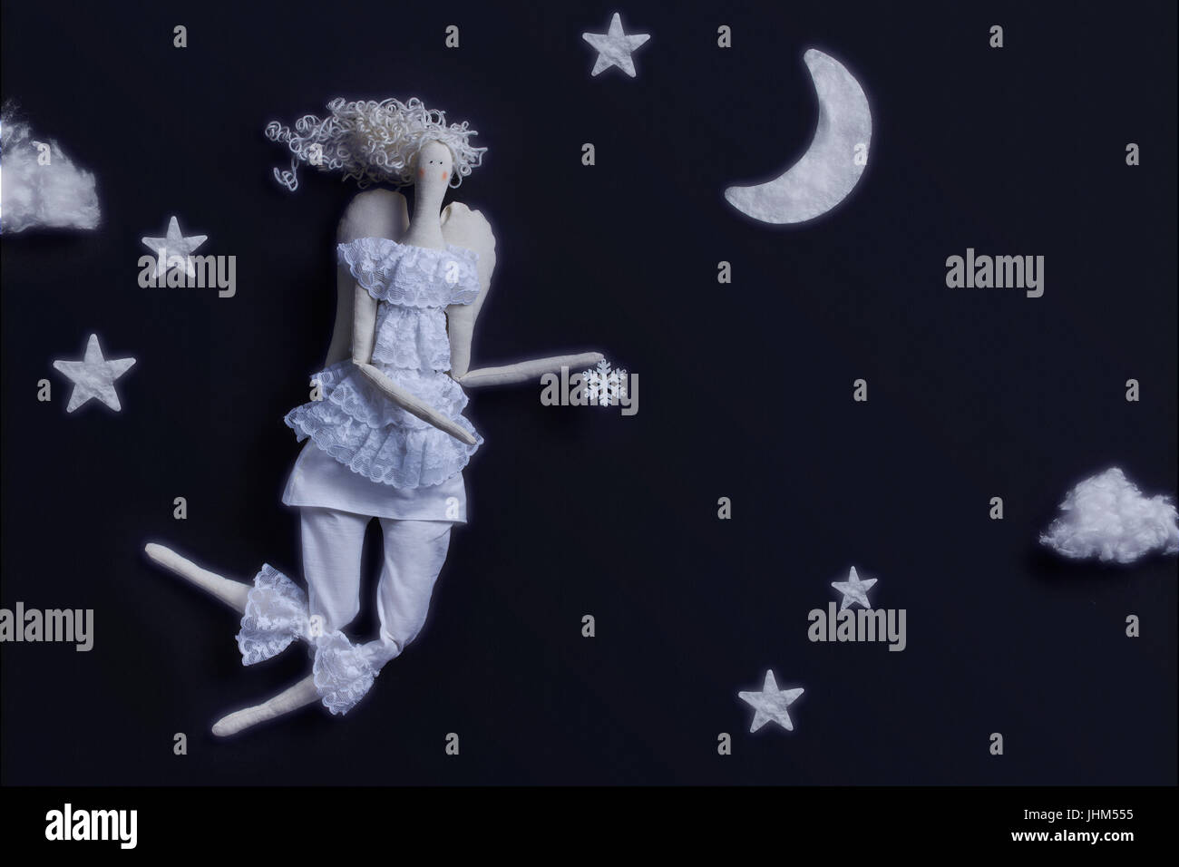 Flying Angel doll on a black background with a snowflake. Stock Photo