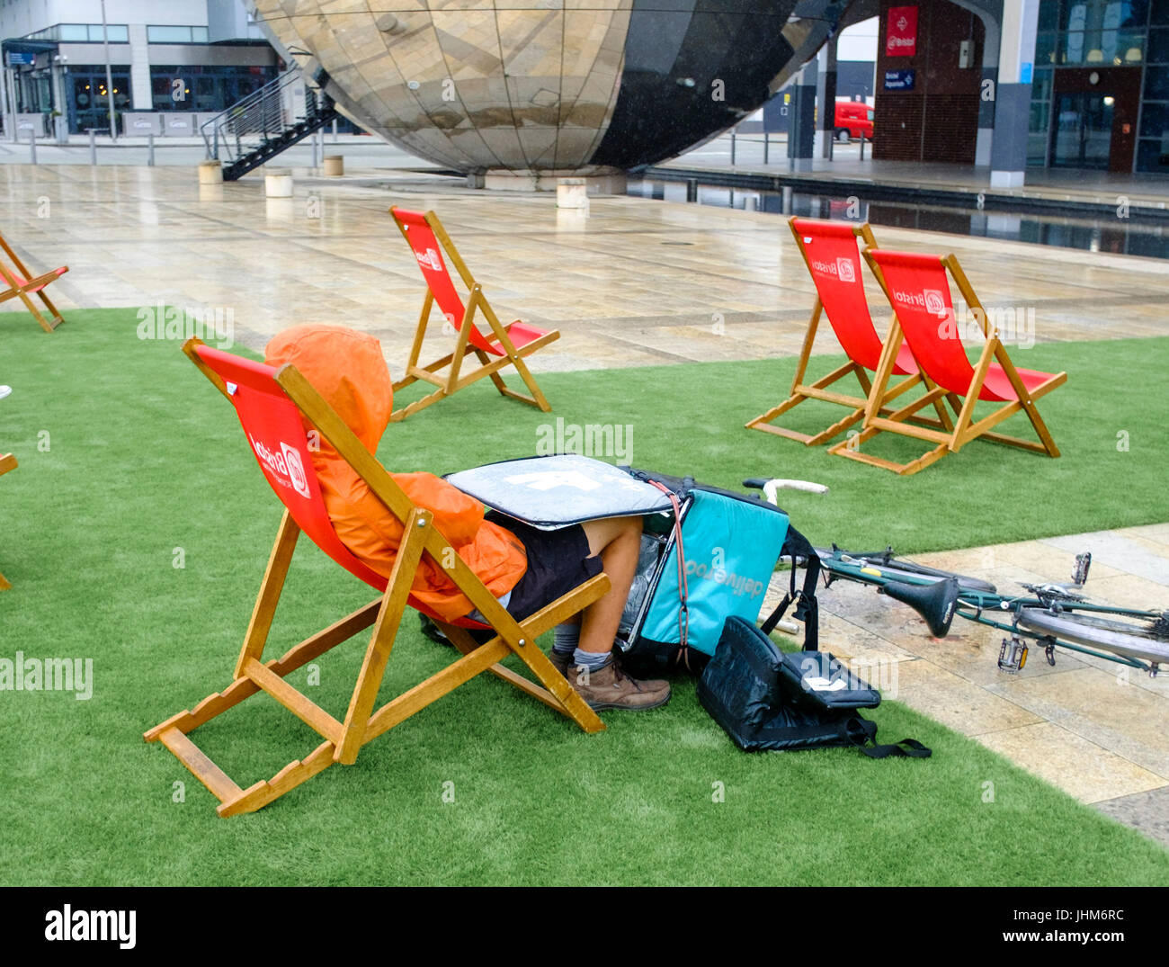 Deliveroo Rider sheltering from the Rain in Bristol Stock Photo