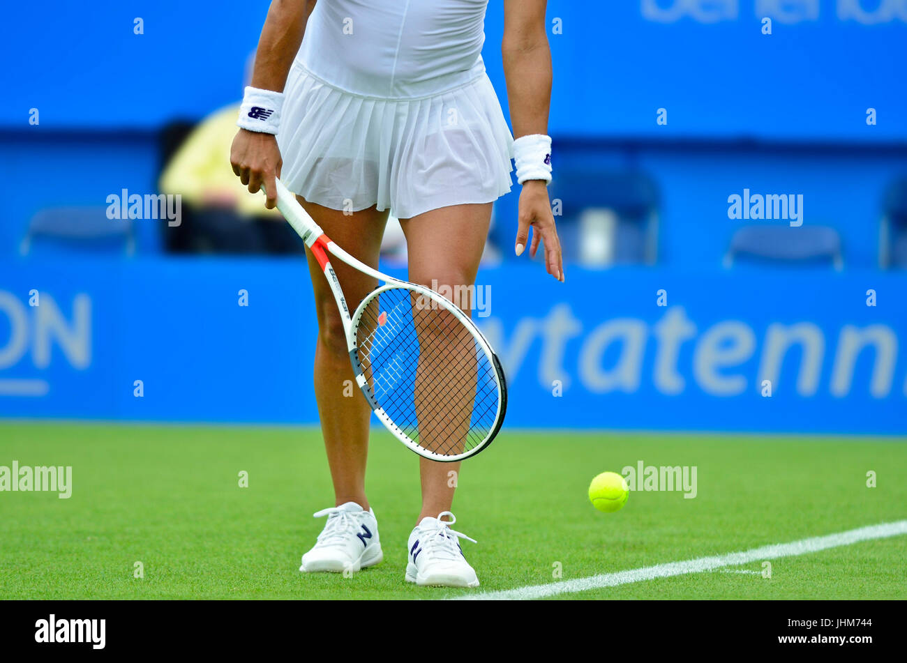 Female tennis player (Heather Watson) bouncing the ball before serving Stock Photo