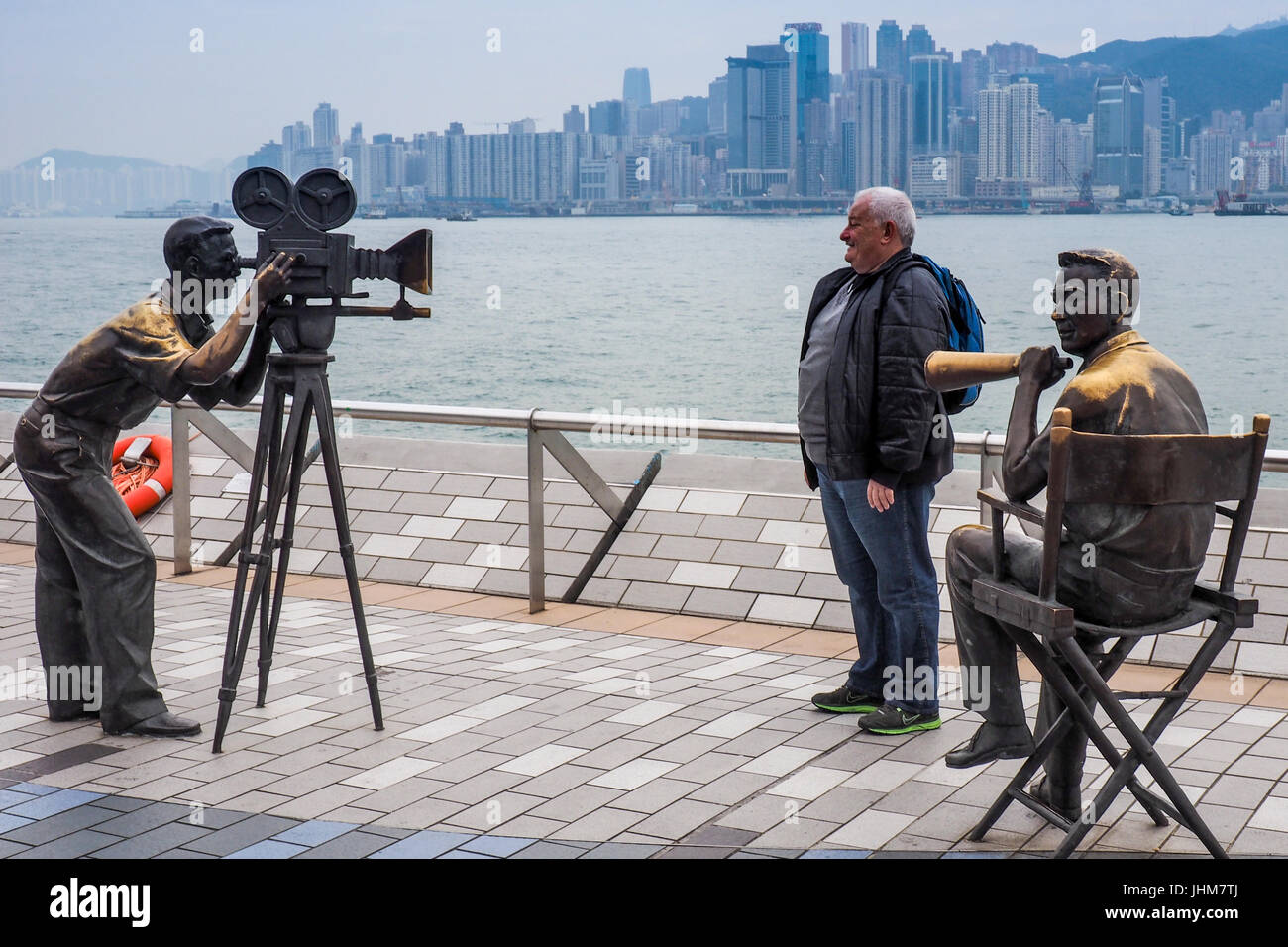 A tourist posing for a photograph in the Avenue of the Stars, Kowloon, Hong Kong. Stock Photo