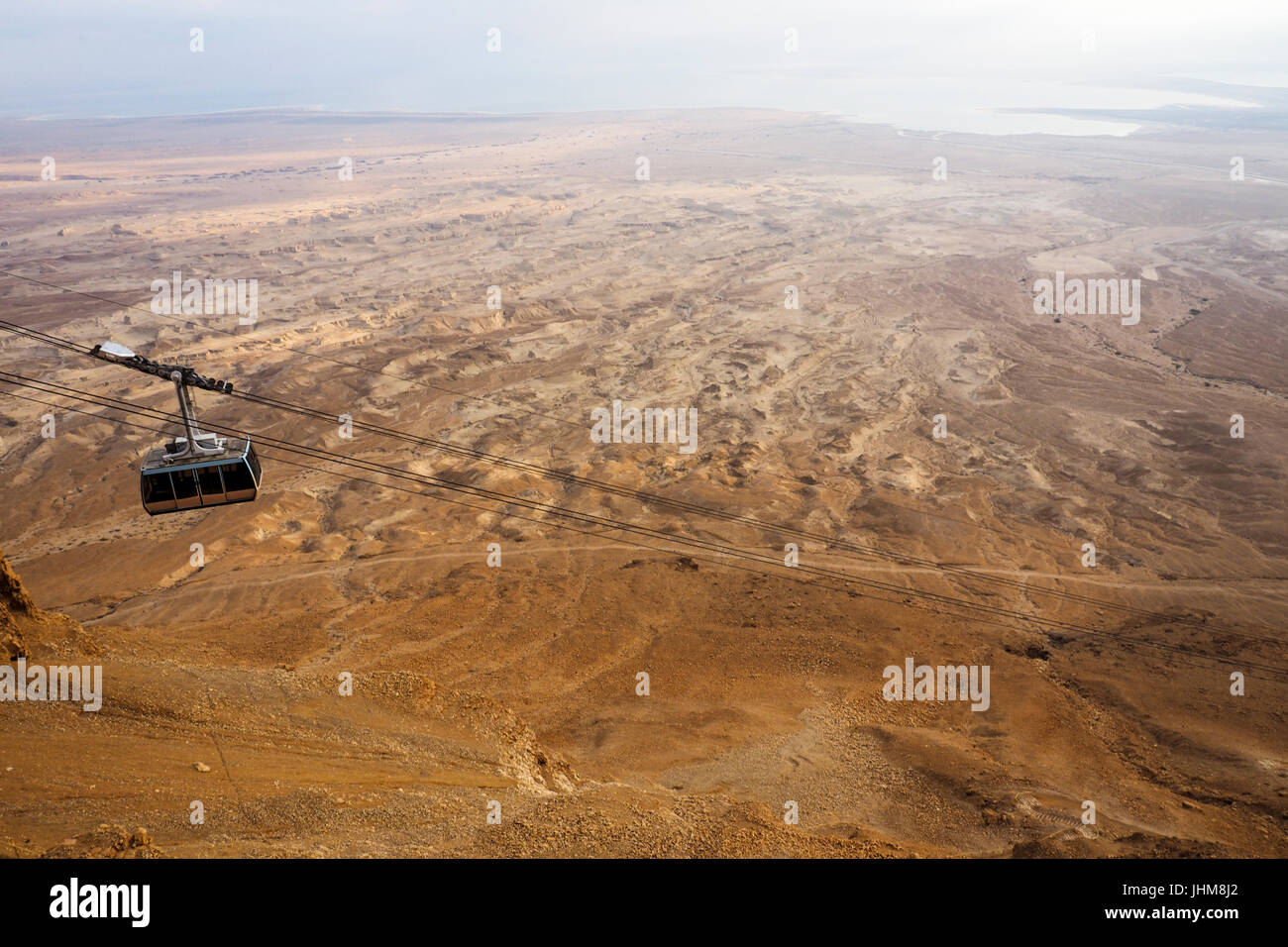 The Masada cableway car descending from Mt Masada, and the Dead sea in the distance. Stock Photo