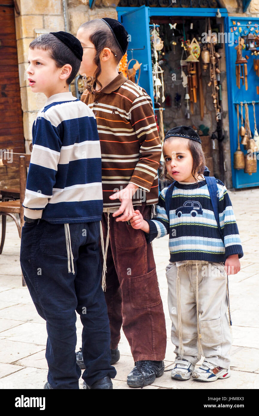 Three religious Jewish schoolchildren standing together in a street in Safed, Israel. Stock Photo