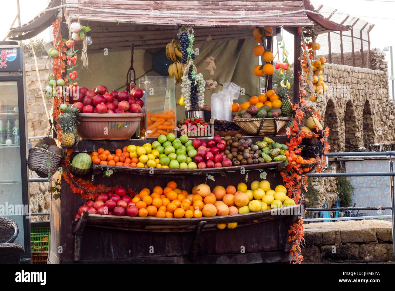 A stall loaded with a variety of fruits for making juice in an outdoor market in Acre, Israel. Stock Photo