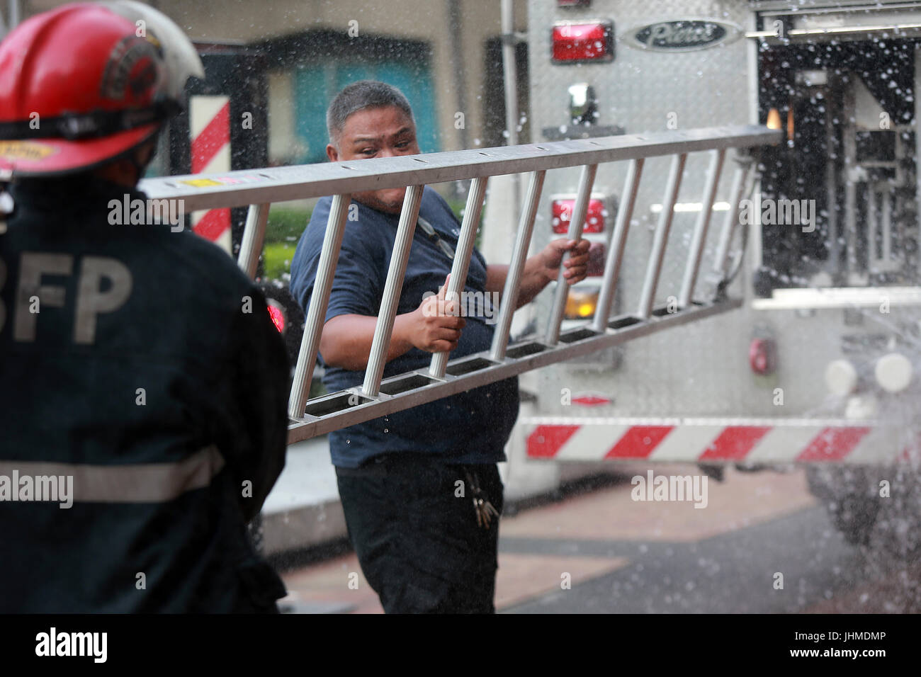 Quezon City, Philippines. 14th July, 2017. Firefighters carry a ladder