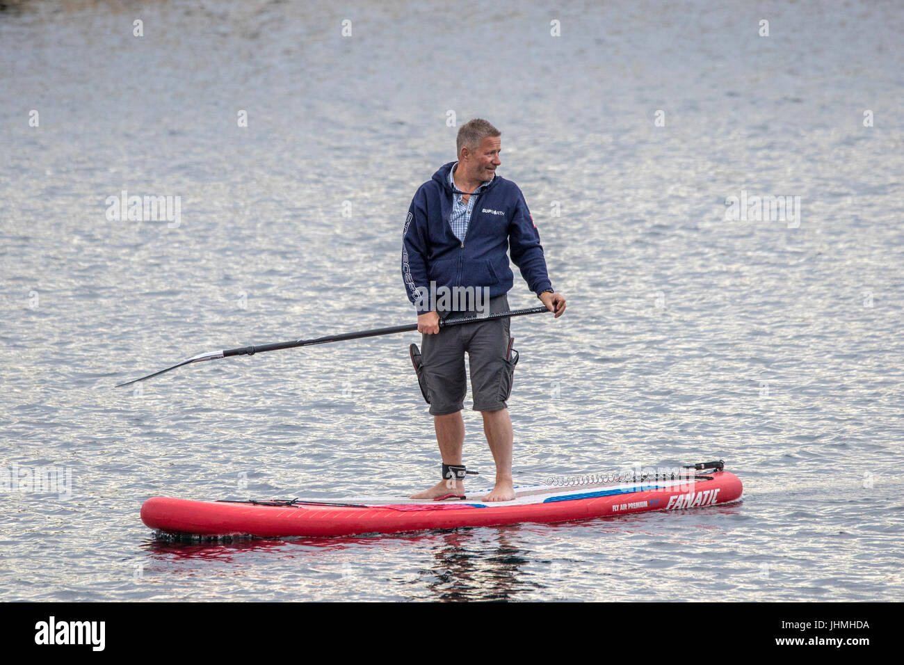 Southport, Merseyside, 14th July 2017. UK Weather.   A much cooler grey evening doesn't stop tourists heading to the pier and seafront,  Stand Up Paddle Boarding,  paddleboarding, paddle boarders surfing at Southport in Merseyside.  With heavy rain downpours expected people were eager to make the most of the dry weather before the rain arrives.   Credit: Cernan Elias/Alamy Live News Stock Photo