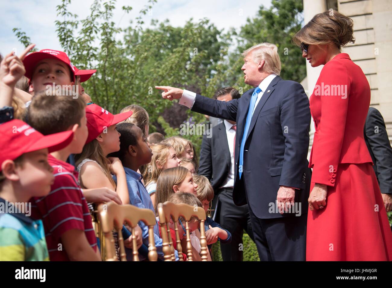 U.S. President Donald Trump and First Lady Melania Trump greet children during an event honoring American veterans at the U.S. Ambassadors Residence on the eve of Bastille Day July 13, 2017 in Paris, France. The first family is in Paris to commemorate the 100th anniversary of the United States’ entry into World War I and attend Bastille Day celebrations. Stock Photo