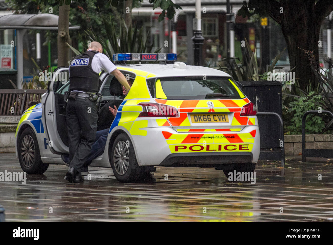 Merseyside Police talking to suspect detained in Police car inSouthport, Merseyside, UK. 15th July, 2017. Wet start to the day in the resort with a forecast for four hours continuous rain as the town finalises preparations for the Open Golf Tournament. Credit; MediaWorldImages/Alamy Live News Stock Photo