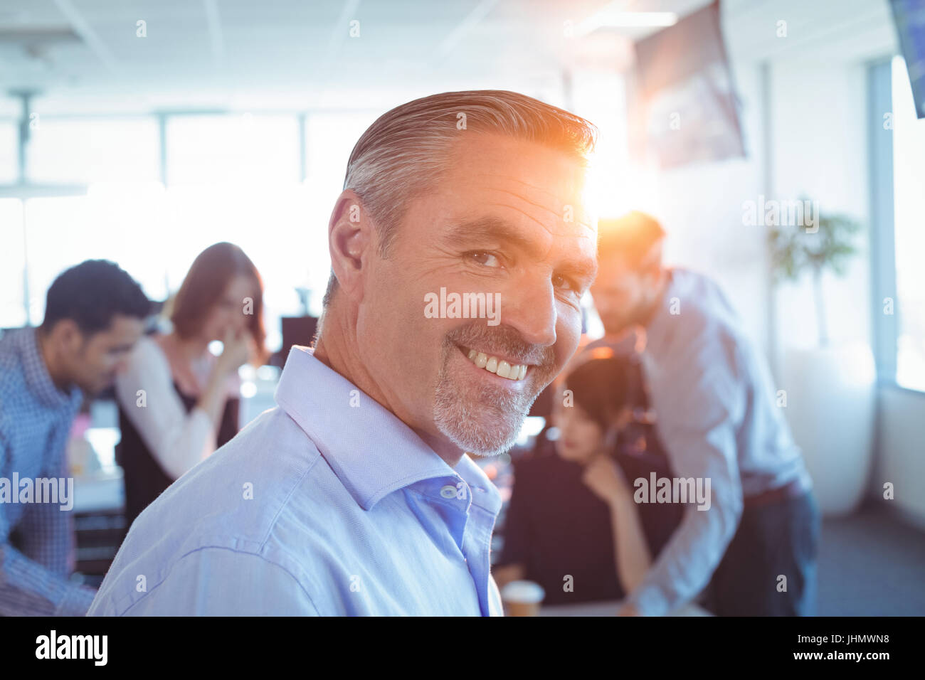 Portrait of smiling businessman at office Stock Photo - Alamy