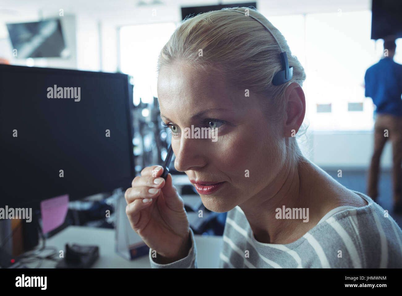 Thoughtful businesswoman wearing headphones at office desk Stock Photo ...