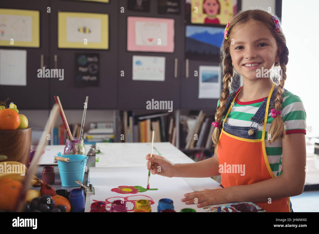 Portrait of smiling girl painting at desk in classroom Stock Photo - Alamy