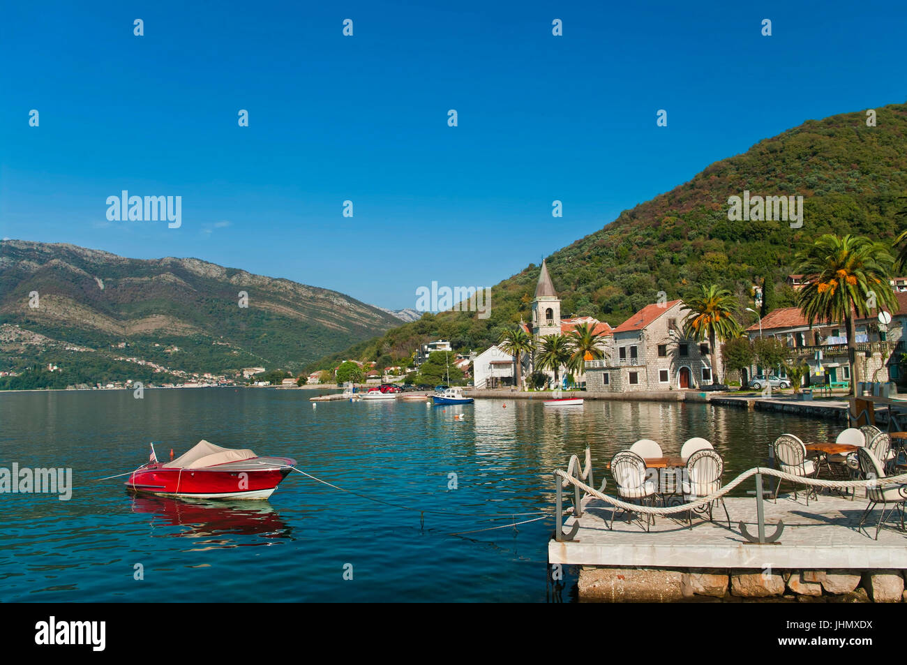 seafront restaurant and Church of Saint Roch at the back, Tivat, Montenegro Stock Photo