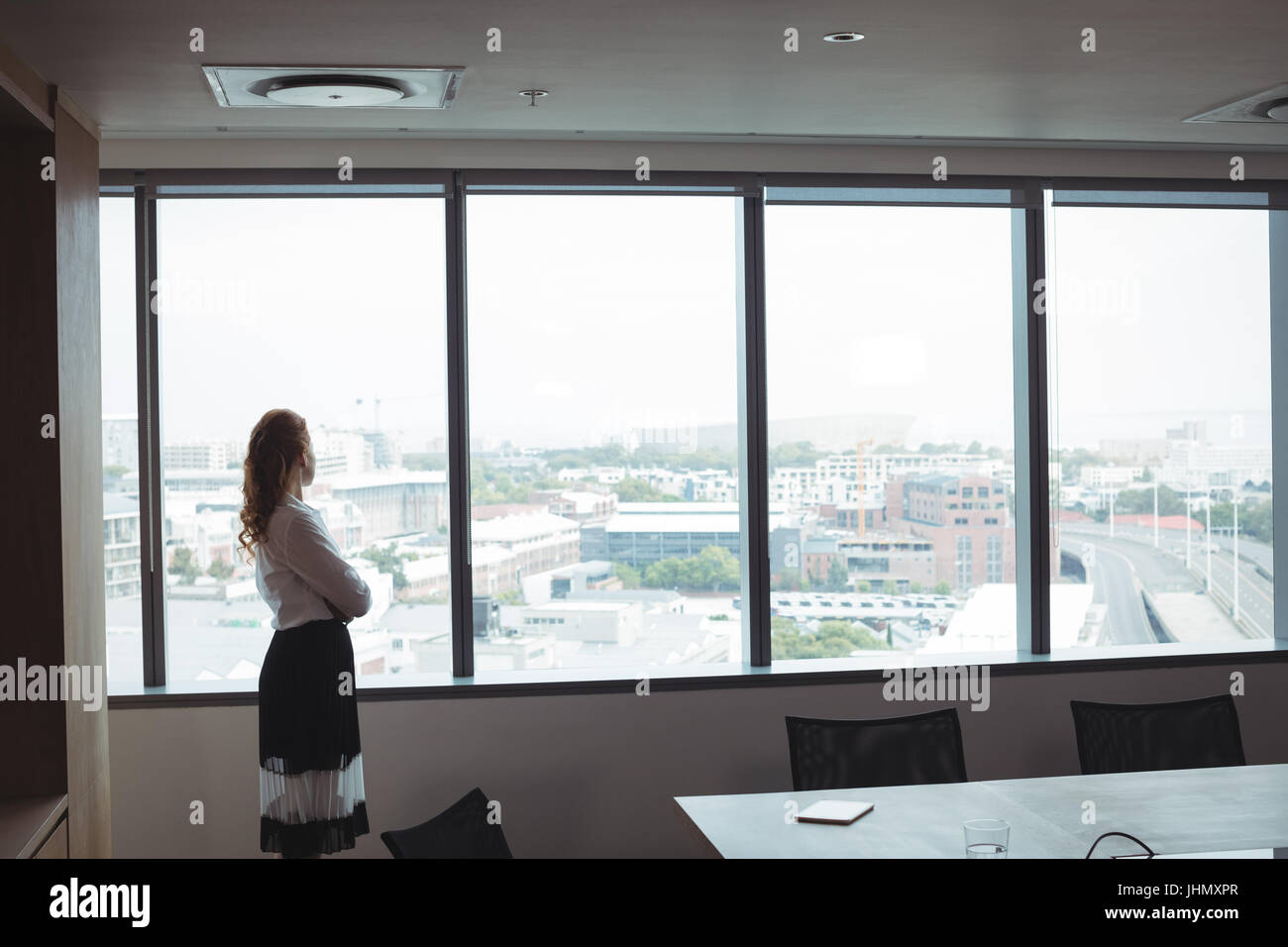 Side View Of Businesswoman Looking Out Through Glass Window