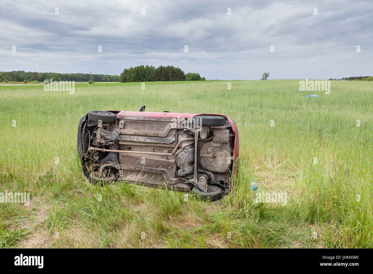 Car wreck lying on the side in a grain field Stock Photo