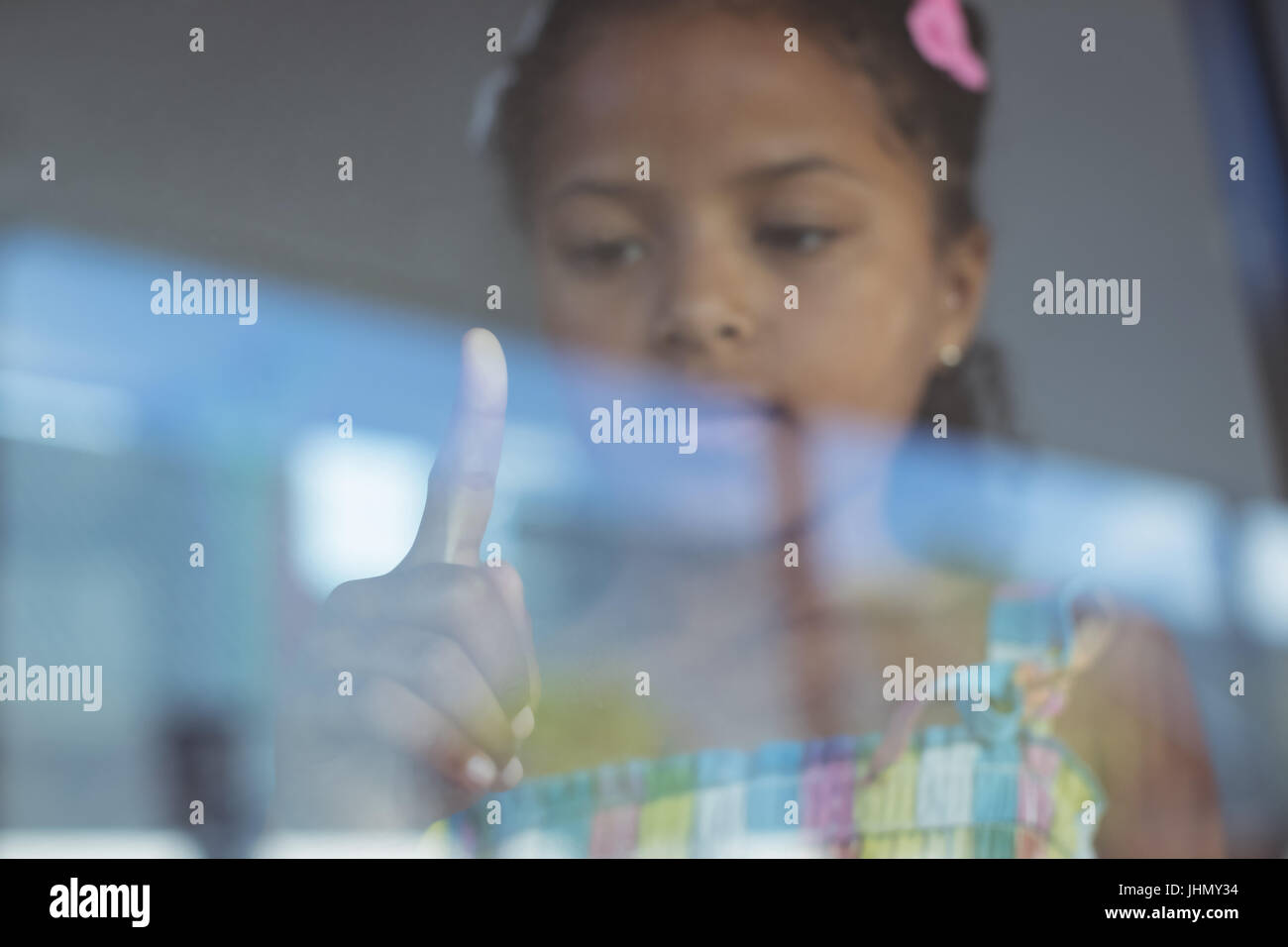Girl touching window glass of school Stock Photo